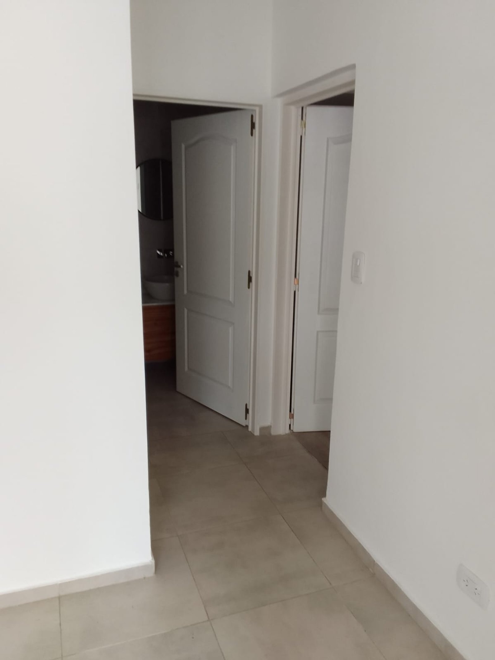 Pasillo con puertas blancas y piso de cerámica beige — proyecto Casa en Sarandi, por Arquitecto Guido Niccoli, en B1872 Sarandí